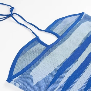 Close-up of blue knit halter top featuring textured fabric and adjustable strap ties