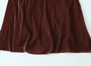 Vue détaillée de l'ourlet de la robe midi en velours marron montrant la texture du tissu