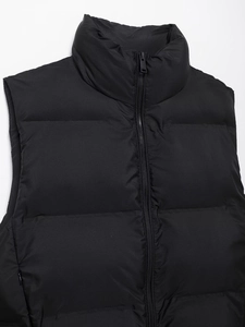 Detail of black puffer vest with stand collar, horizontal quilting, and quality zipper closure