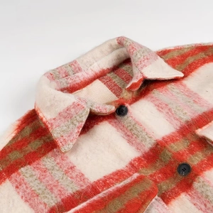 Detail of red and white plaid coat showing fuzzy texture, lapel collar and black buttons