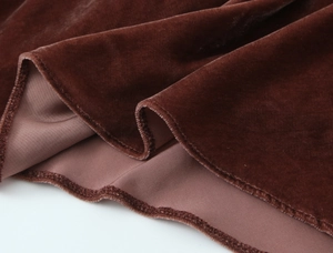 Gros plan détaillé du tissu en velours marron foncé avec texture douce et ourlet raffiné