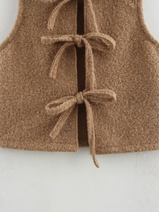 Detail view of the brown fuzzy wool texture and bow tie closures on the women's vest