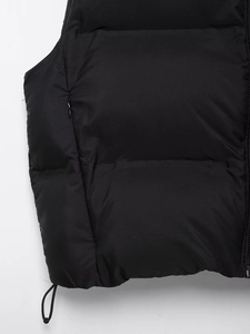 Detailed close-up of a quilted vest showing the hidden zipper pocket and adjustable hem cord