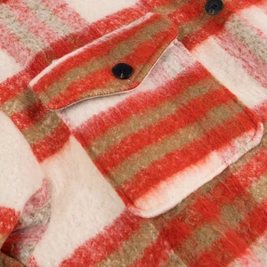 Detail of red and white plaid coat showing soft fuzzy texture and black button on pocket