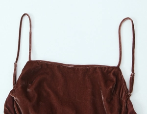 Détail de fines bretelles réglables sur une robe midi en velours marron avec boucle