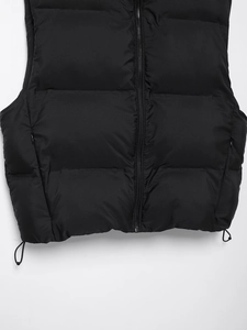 Detail of black quilted vest showing zipper closure and adjustable drawstring hem