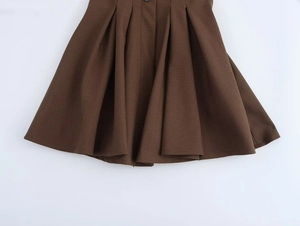 Detail of brown houndstooth pleated skirt fabric with classic retro texture