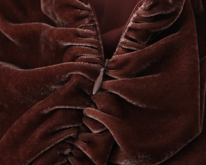 Détail macro de la robe en velours marron montrant le zip invisible et le plissé au dos