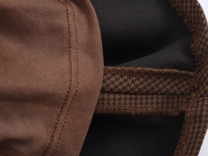 Close-up of brown plaid elastic band and fine knit fabric with neat double stitching