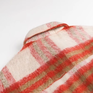 Detail of red and cream plaid wool jacket collar with fuzzy mohair texture