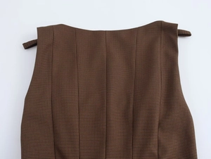 Macro texture of brown houndstooth fabric with detailed shoulder strap design and stitching