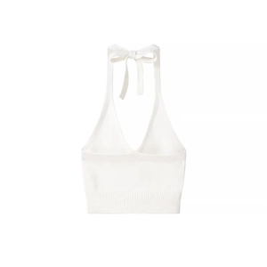 Detail of white knit halter top showing deep V-neck and bow tie closure at the back