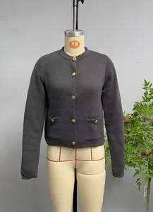 Detail view of charcoal grey knit cardigan with embossed gold metal buttons and pockets