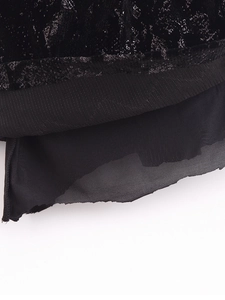 Dettaglio dell'abito in velluto nero con paillettes e strati di chiffon pregiato
