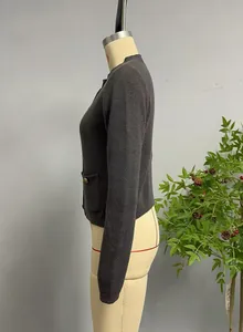 Detailed texture of charcoal grey knit cardigan with metallic buttoned side pockets