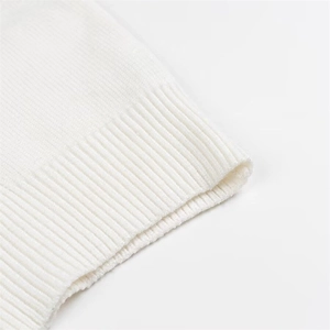 Detailed close-up of white ribbed knit texture and soft elastic hem of the crop tank top