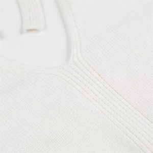 Detail shot of the V-neckline featuring premium ribbed knit texture in creamy white fabric