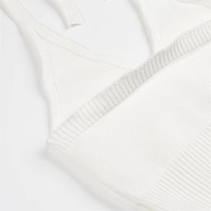 Close-up of white knitted halter top with fine ribbing detail and slender shoulder straps