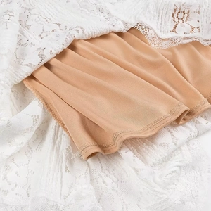 Detailed view of elegant white lace overlay and beige lining on French strapless maxi dress