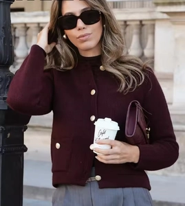 Detail of burgundy ribbed knit cardigan with elegant gold buttons and patch pockets