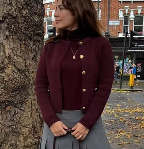 Detail of burgundy knit cardigan with gold buttons and matching turtleneck top in London