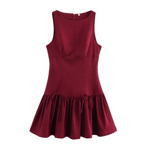 Detailed view of wine red sleeveless dress with decorative waist bows and pleated hemline