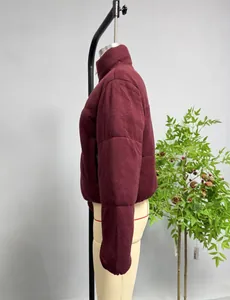 Detail view of burgundy knitted cotton jacket featuring a high collar and side zipper pocket