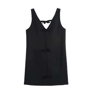 Detail of a black sleeveless velvet dress featuring three decorative bows on the open back