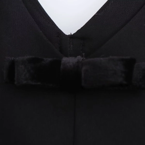 Close-up of V-neckline with black velvet bow detail on women's straight short dress