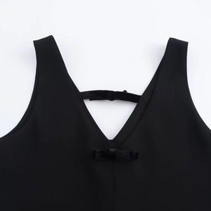 Detail of V-neckline with black velvet bow accent on the straight mini dress