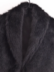 Vue macro détaillée de la texture de la fourrure synthétique noire de ce gilet femme
