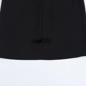 Detail of a velvet mini dress showing a delicate black bow on the straight hemline