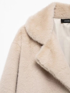 Detail of faux fur coat lapel featuring dense texture and smooth inner lining