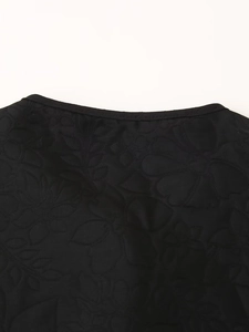 Close-up of black jacket neckline featuring intricate floral embroidery and woven texture