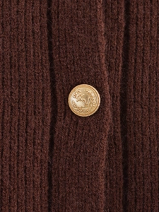 Detail of dark brown ribbed knit fabric with an embossed gold anchor metal button