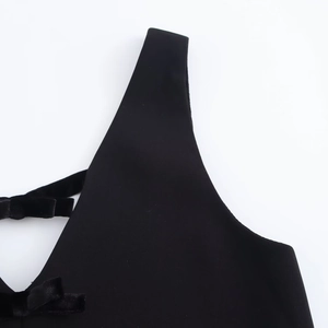 Detailed view of the black matte fabric with a velvet bow accent and wide shoulder strap