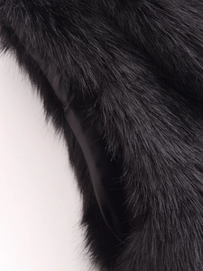 Vue détaillée de la texture en fausse fourrure et de la doublure lisse de la veste noire