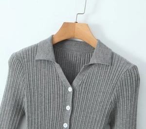 Detail view of the gray ribbed knit texture with polo collar and white buttons