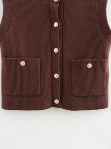 Detailed close-up of dark brown knit vest with ribbed texture and gold embossed buttons