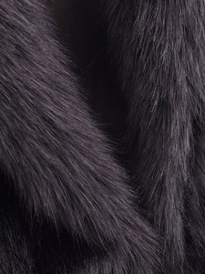 Détail macro de la texture luxueuse en fausse fourrure violet foncé à haute brillance