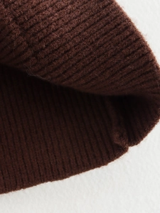 Macro detail of brown ribbed knit fabric texture showing high-quality wool fiber