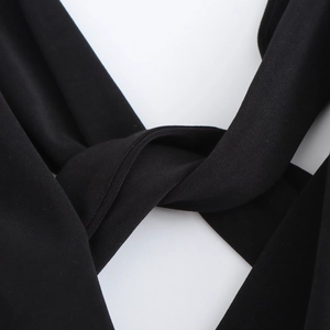 Detail des Rückenknoten-Designs an diesem schwarzen Midikleid mit Textur und Nähten
