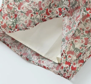 Detailed view of the double-layer floral dress hem with red patterns and white lining