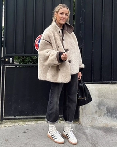 Street style shot of a beige shearling jacket with contrast faux leather trim detail