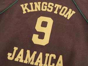 Dettaglio della felpa marrone con stampa Kingston Jamaica e bordo verde