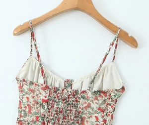 Detailed close-up of floral slip dress featuring adjustable straps and elastic smocked back