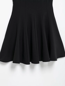 Detail shot of black A-line skirt fabric showing structured folds and clean stitching