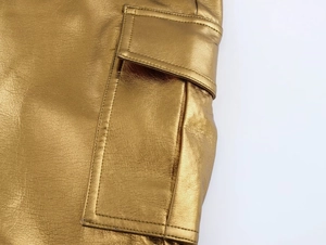 Détail d'un pantalon cargo doré métallisé avec poche à rabat et coutures de haute précision