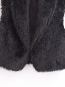 Gros plan d'un gilet en fausse fourrure noire montrant la texture des poils et la doublure