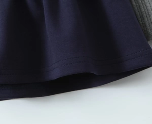 Detail of double-needle stitched hem on navy blue and grey knit patchwork dress